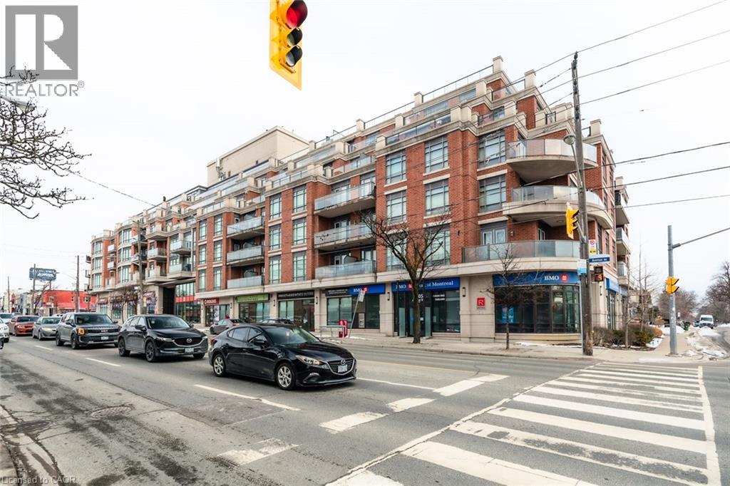 A street view with cars, traffic lights and a building with a REALTOR sign.
