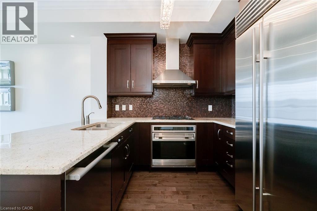 A modern kitchen with dark wood cabinets and stainless steel appliances.