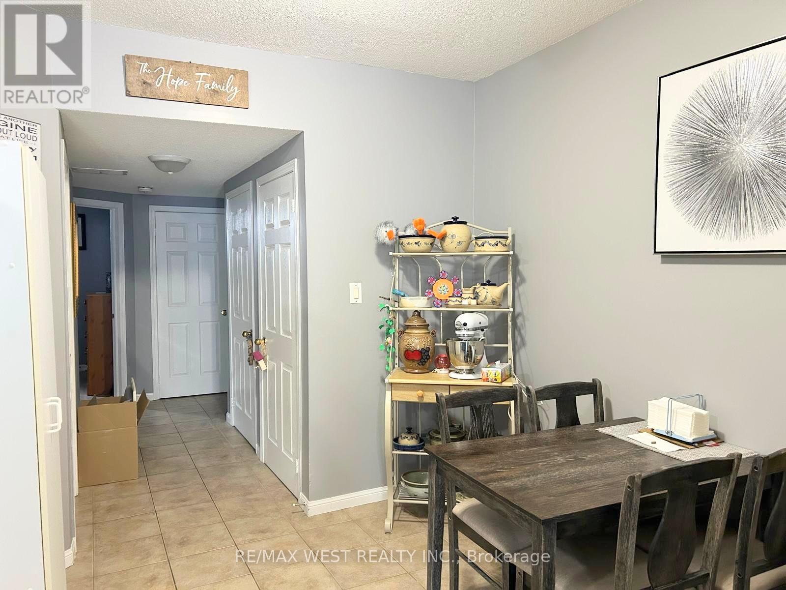 A dining room with a table and chairs and a shelf with various objects on it.
