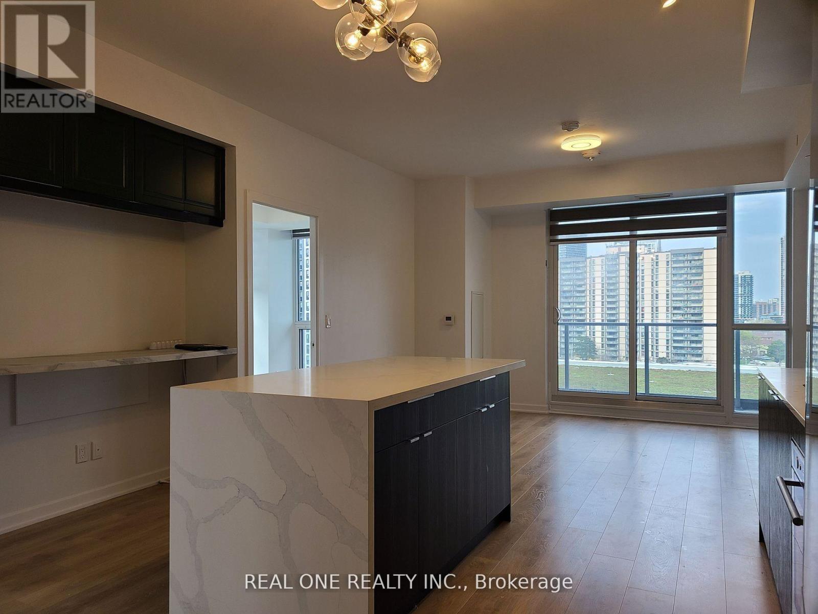 A modern kitchen with a large island and wooden floors.