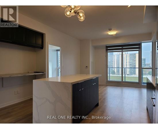 A modern kitchen with a large island and wooden floors.