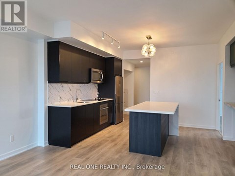 A modern kitchen with dark wood cabinets and a white countertop.