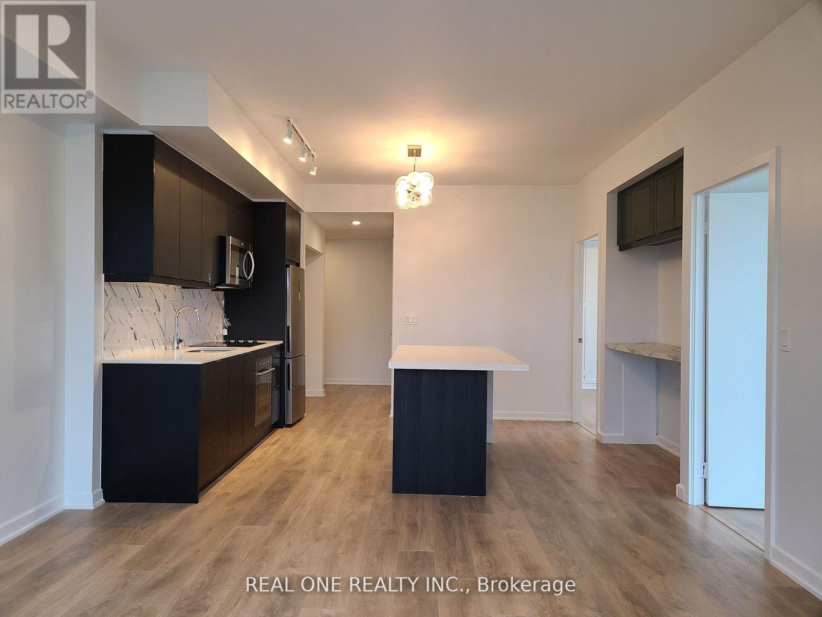 A modern kitchen with dark brown cabinets and a white countertop.