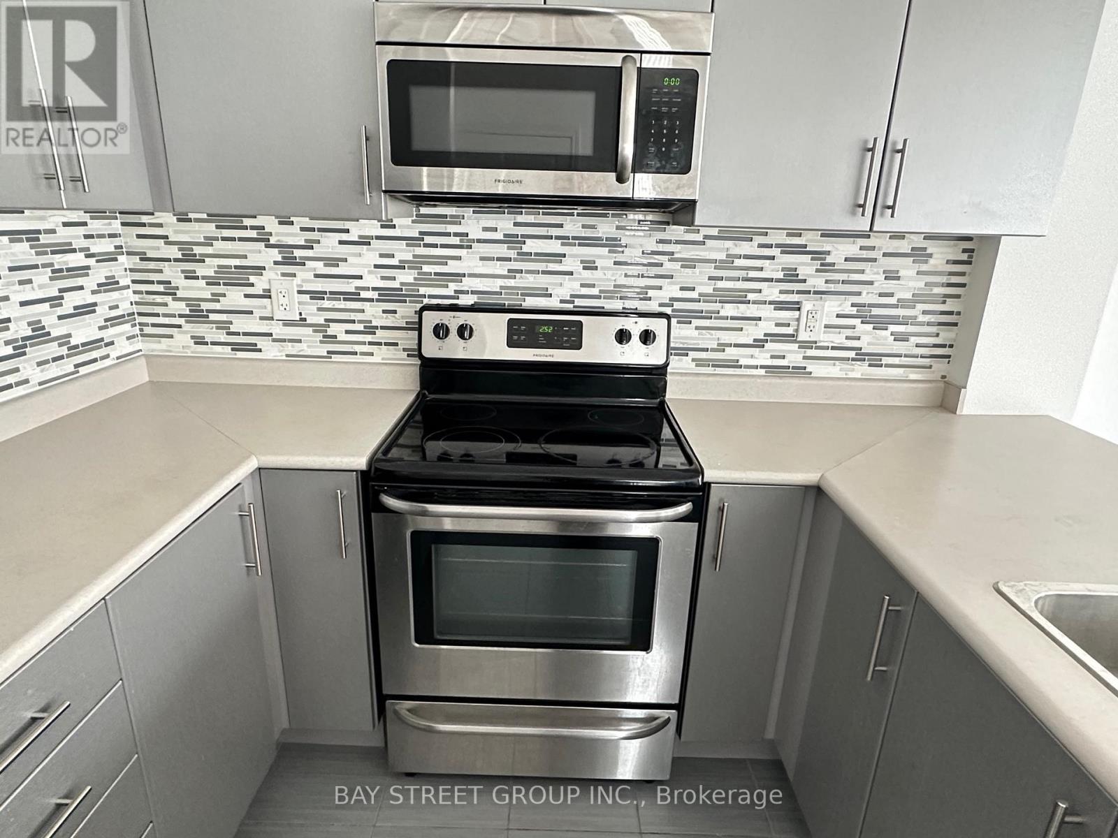 A modern kitchen with a stove top oven and microwave above it.