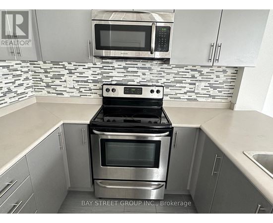 A modern kitchen with a stove top oven and microwave above it.