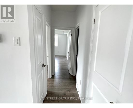 A hallway with white walls and wooden floors.
