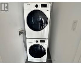 A white Samsung washing machine and dryer in a small room.