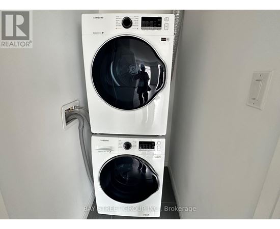 A white Samsung washing machine and dryer in a small room.