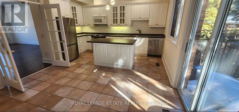 A kitchen with white cabinets and a black countertop.