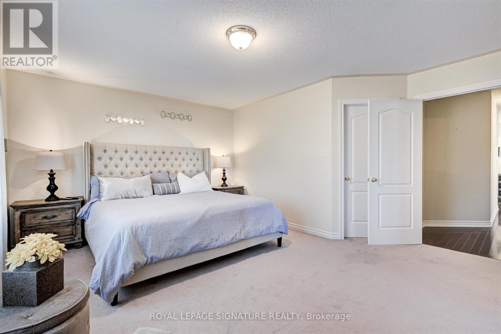 A bedroom with a large bed and a white headboard.