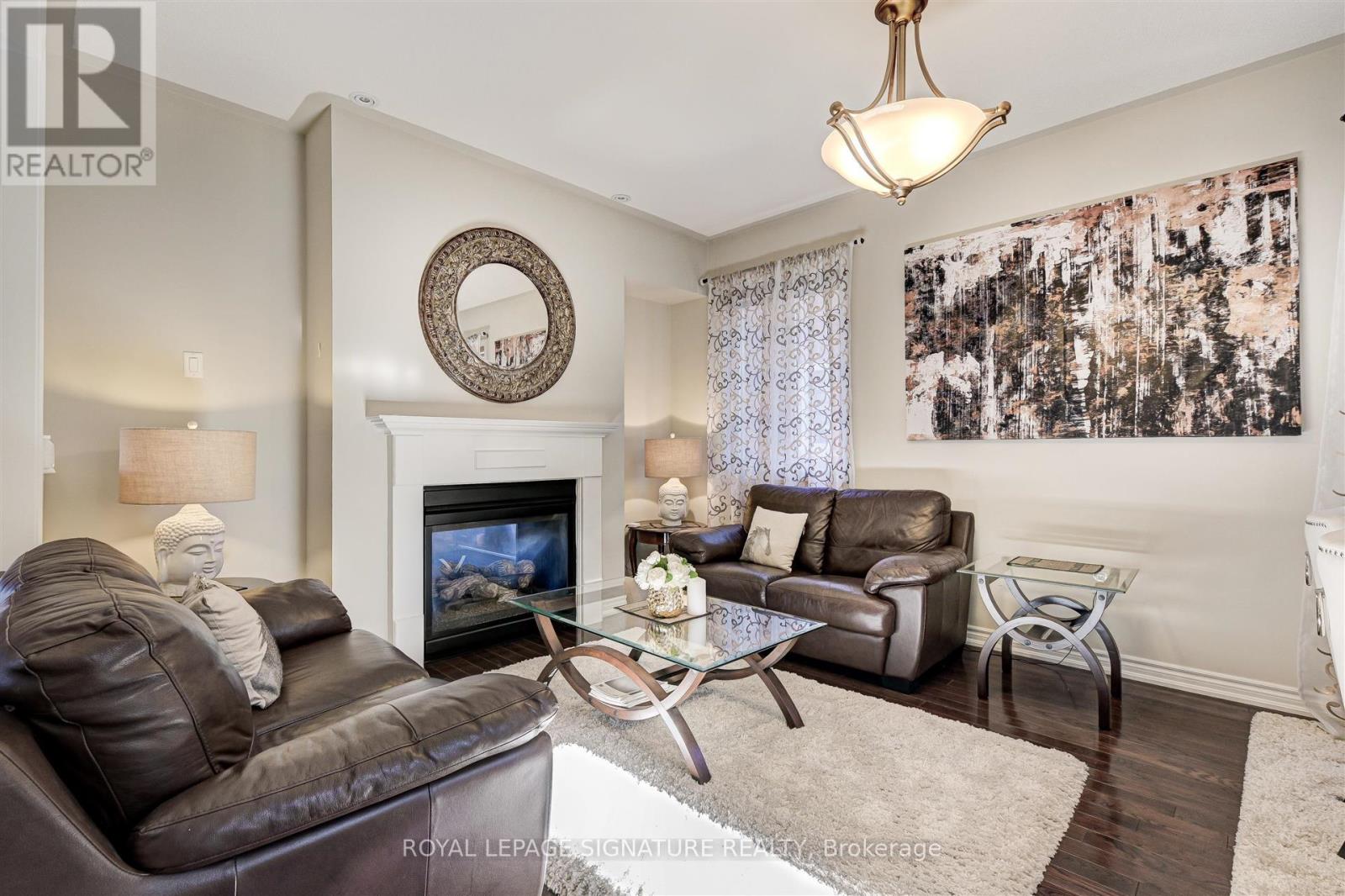A living room with a fireplace and a painting on the wall.