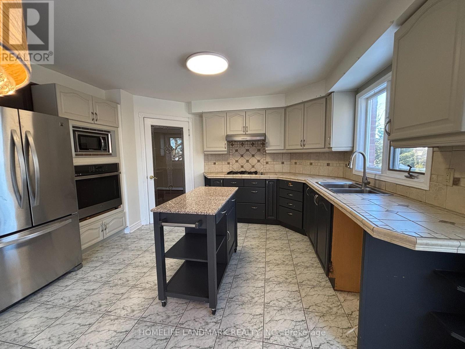 A kitchen with a tile floor and a table in the middle.