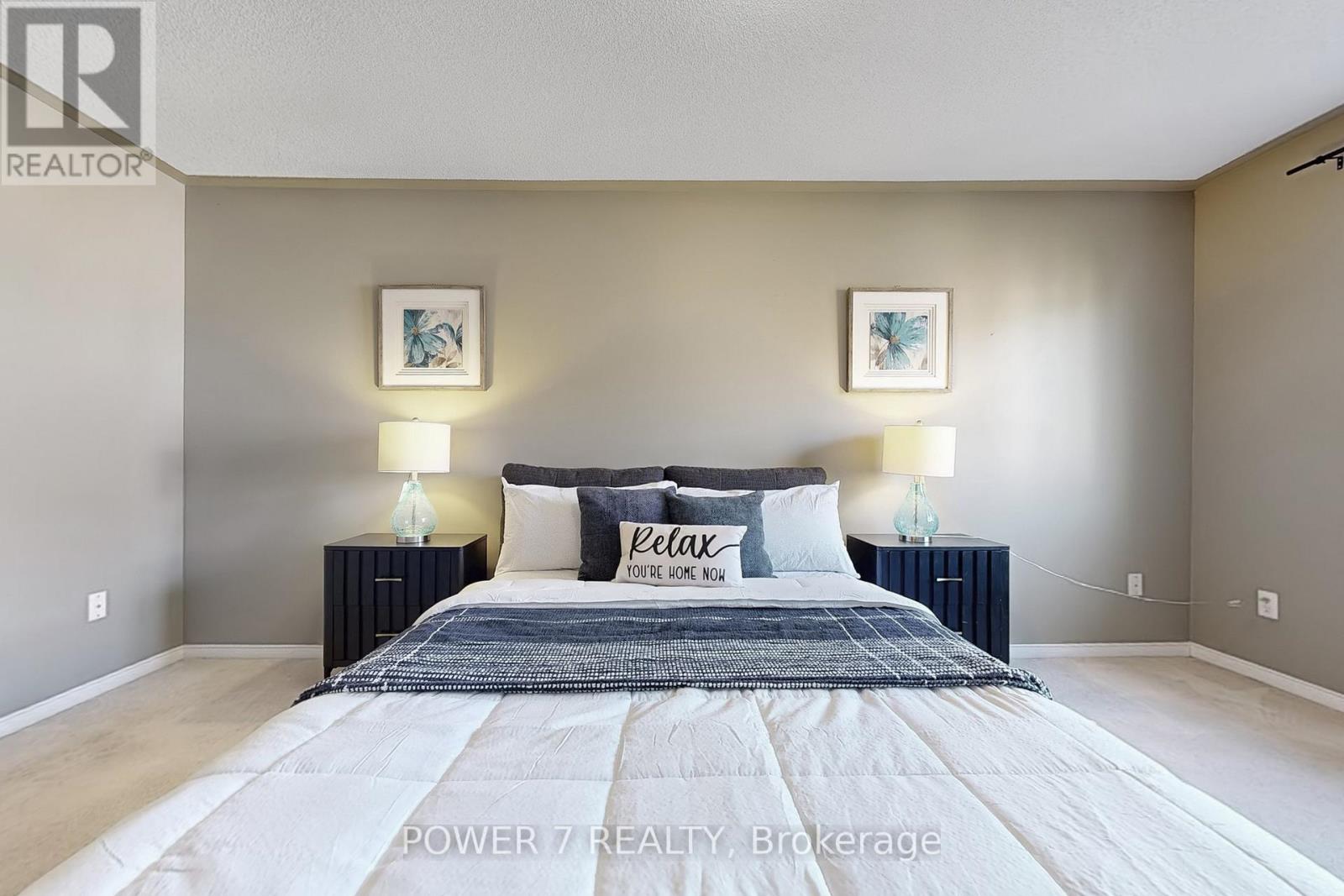 A bedroom with a large bed and two lamps on either side of the bed.