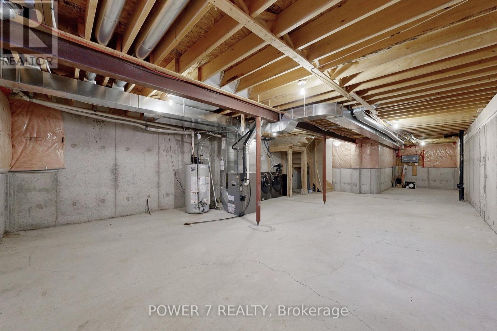 A spacious attic room with exposed wooden beams and ductwork.