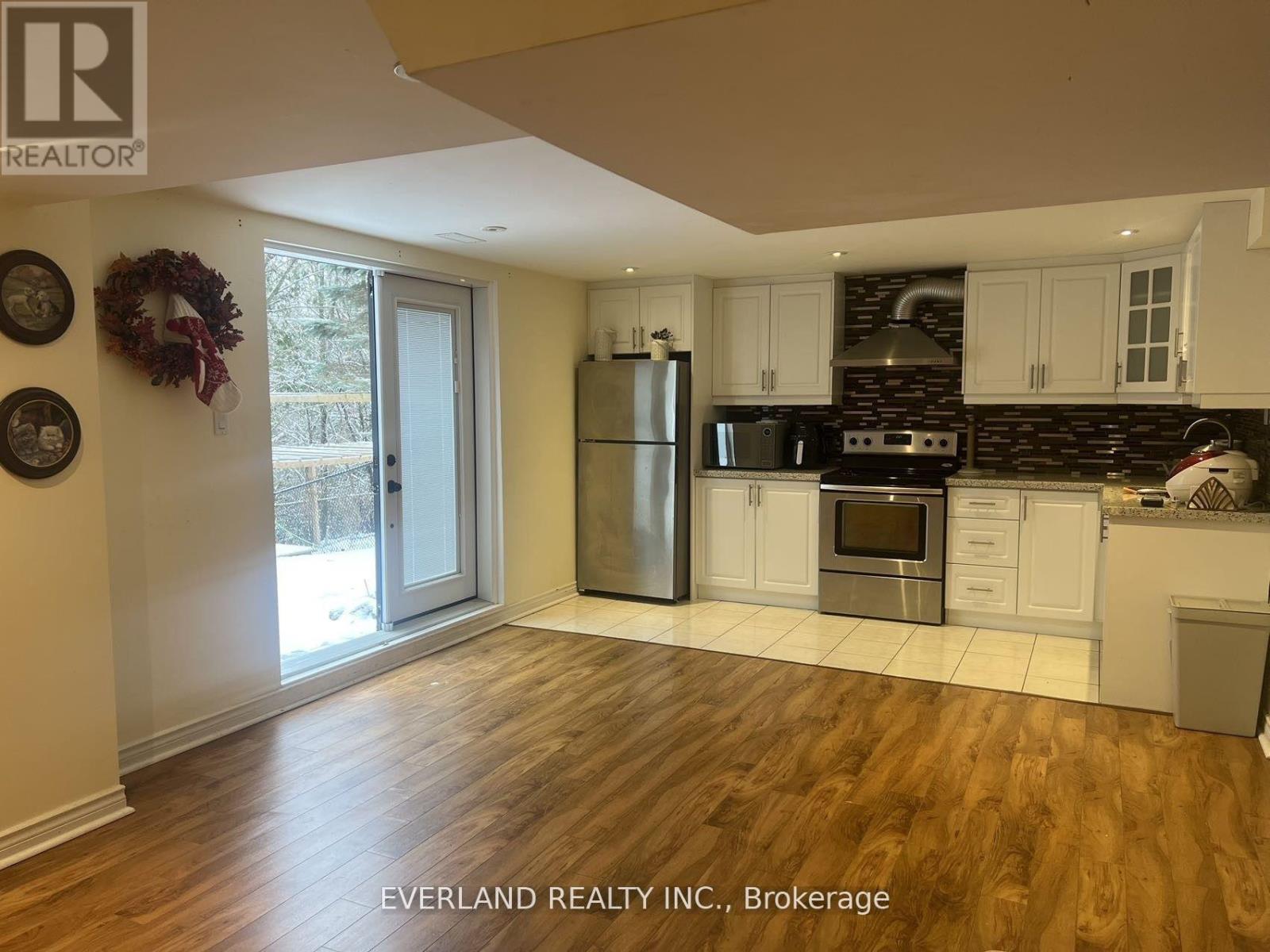 A kitchen with wooden floors and white cabinets.