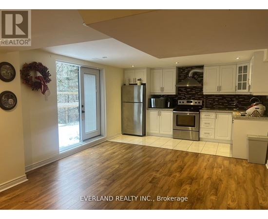 A kitchen with wooden floors and white cabinets.