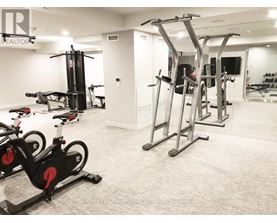 A gym with a row of exercise bikes and a row of pull up bars.