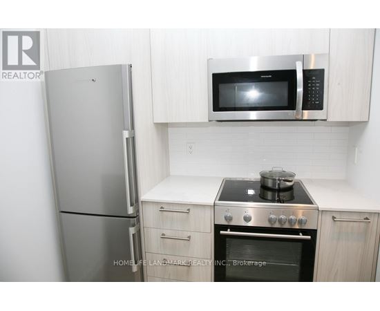 A kitchen with a stove, oven, refrigerator and microwave.