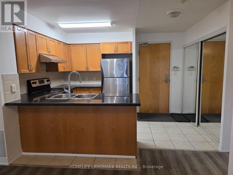 A kitchen with wooden cabinets and a black countertop.