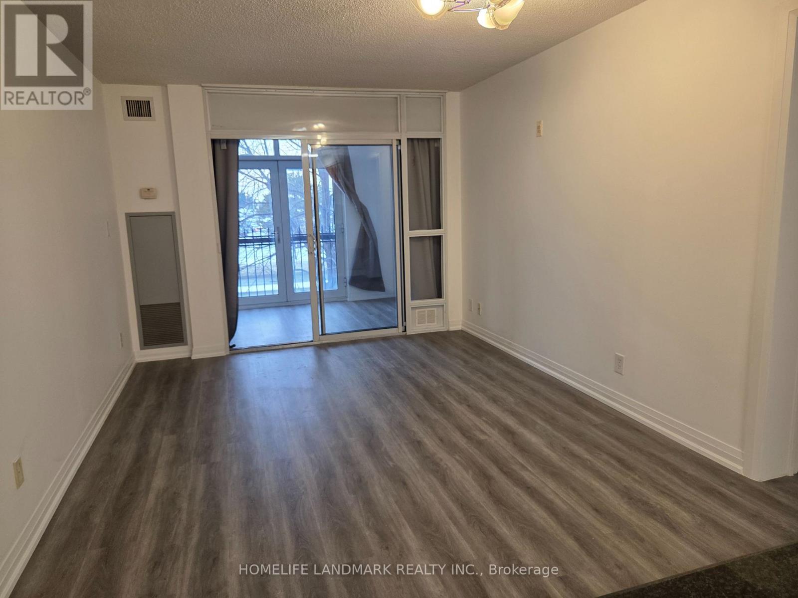 A room with a sliding glass door leading to a balcony.