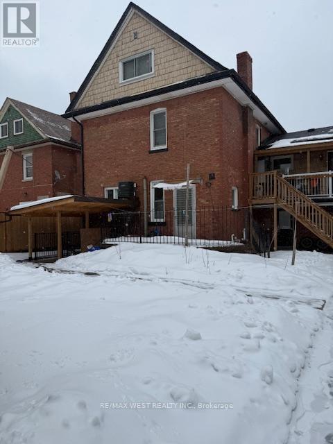 A house with a snow-covered ground in front of it.