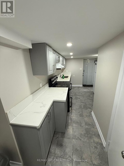 A kitchen with grey cabinets and a white counter top.