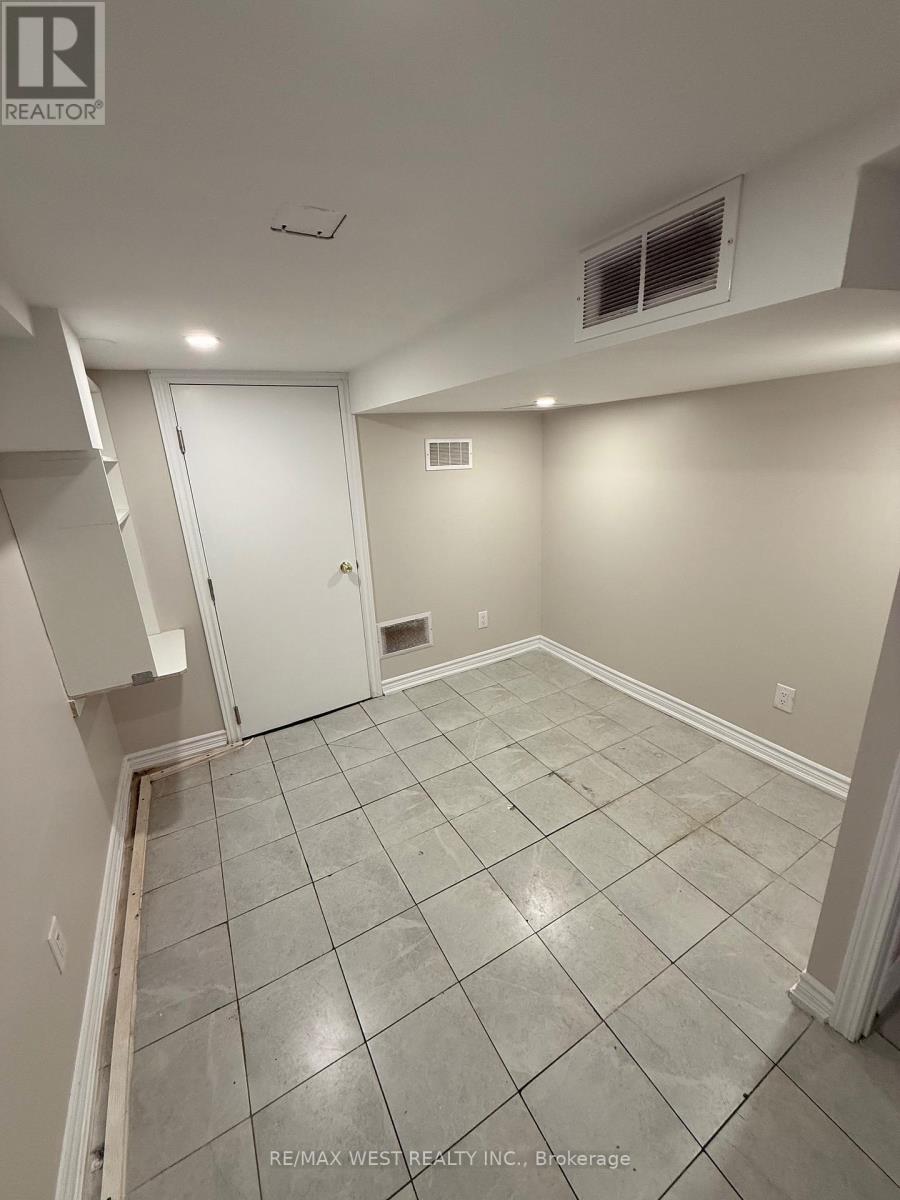 A room with tile flooring and a doorway leading to another room.