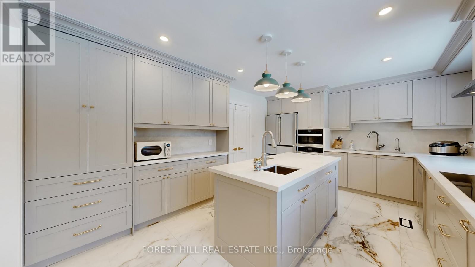 A kitchen with white cabinets and marble countertops.