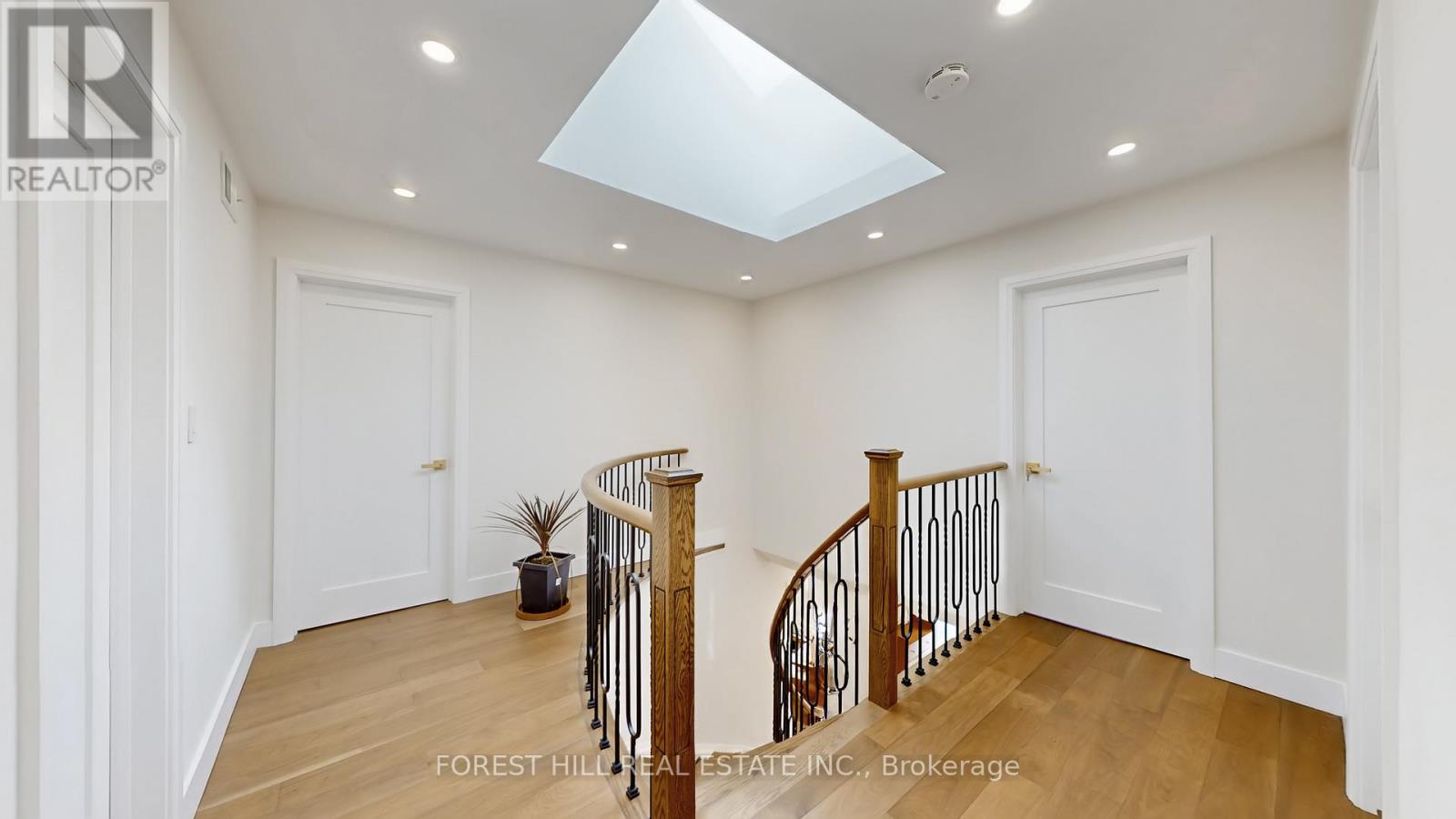 A spacious room with a wooden floor and a skylight.