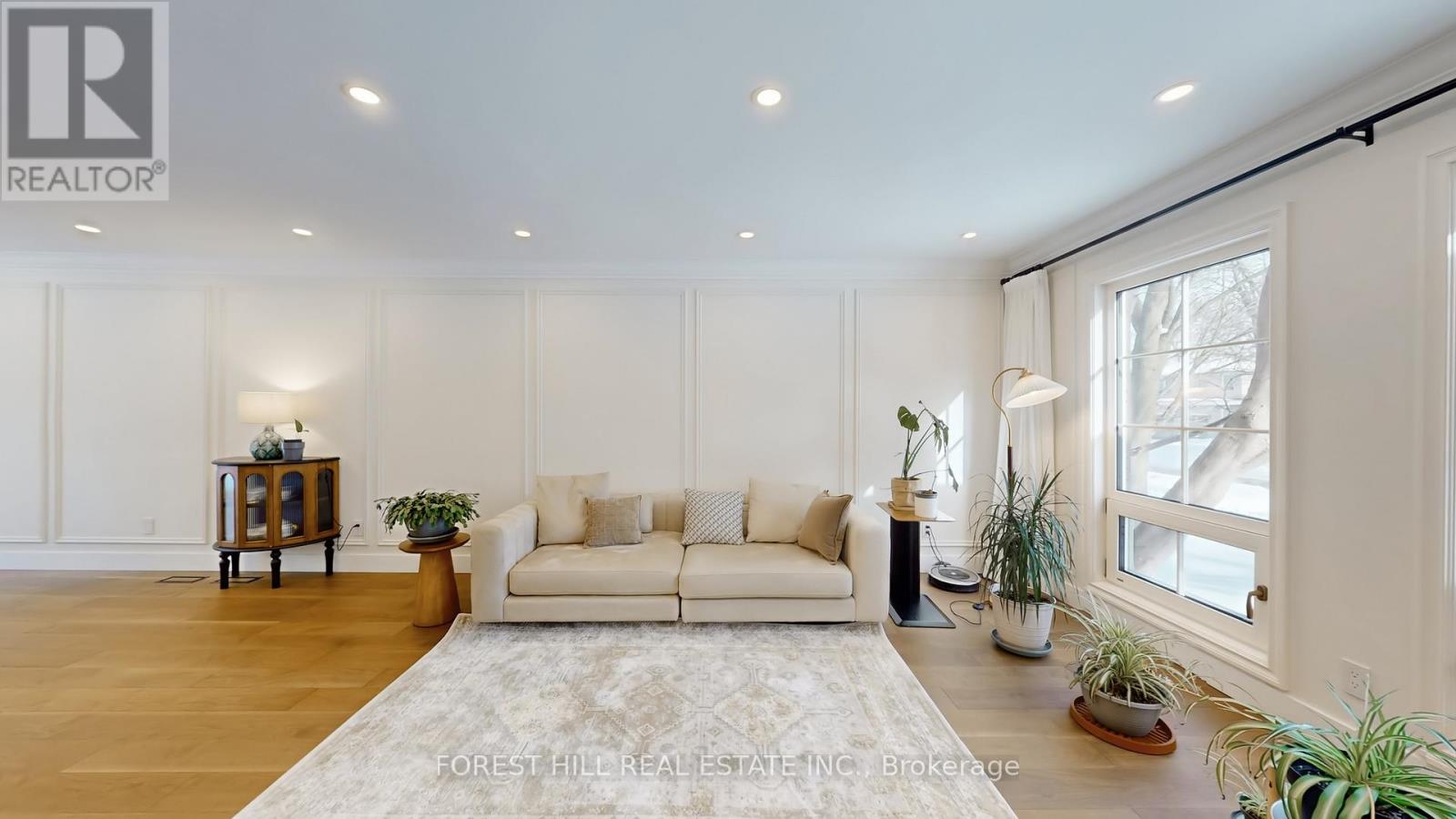 A living room with a white couch and a rug.