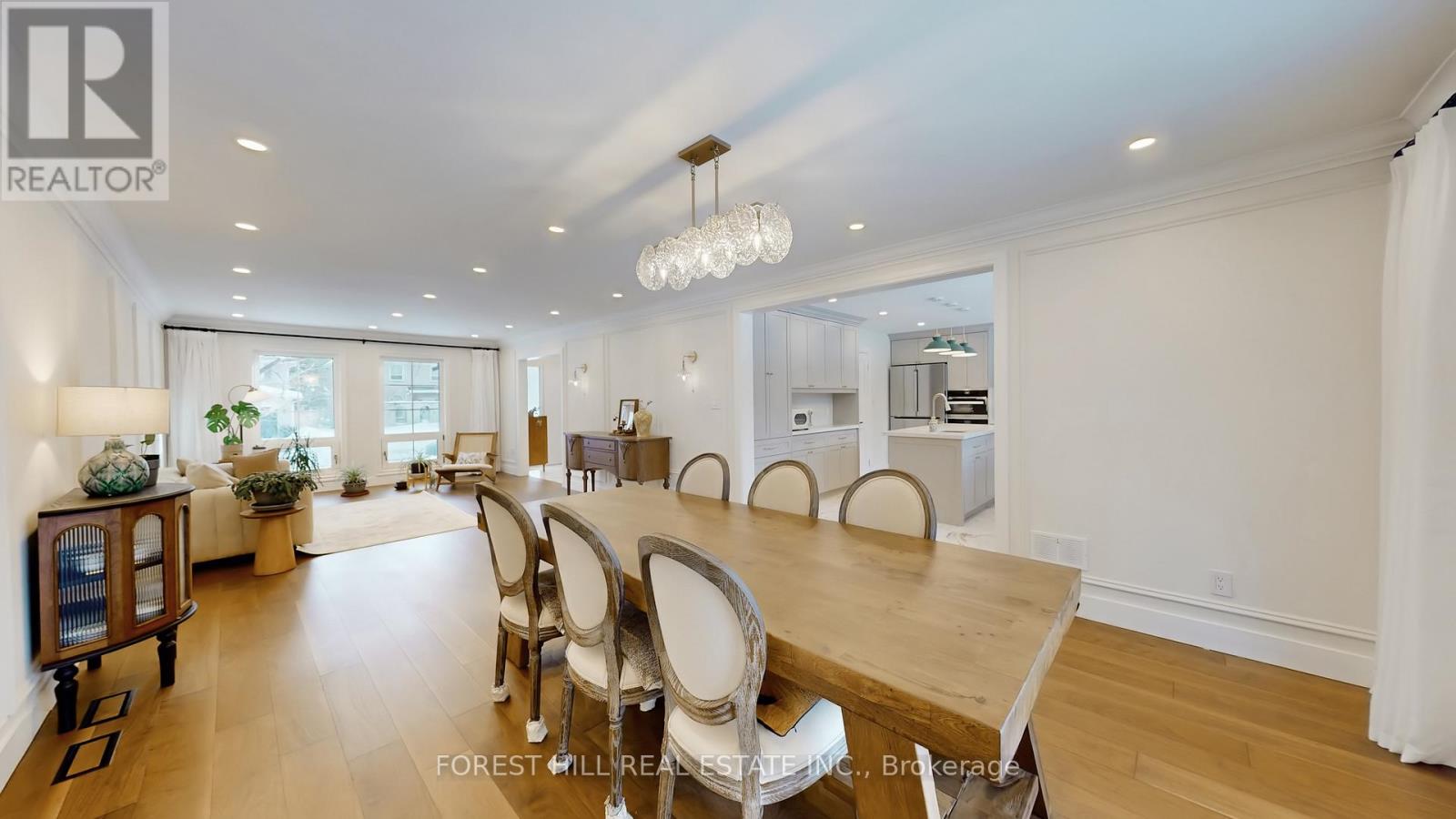 A well-lit dining room with a large table and chairs.