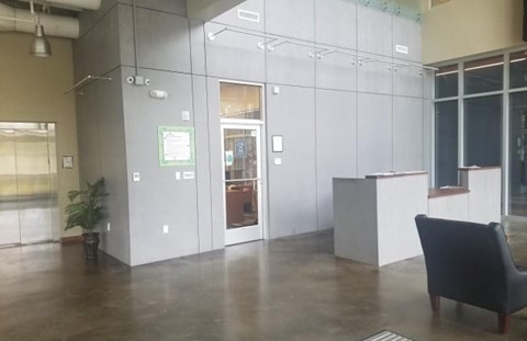 A black chair is in front of a white cubicle.