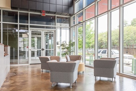 A room with grey chairs and a glass wall.