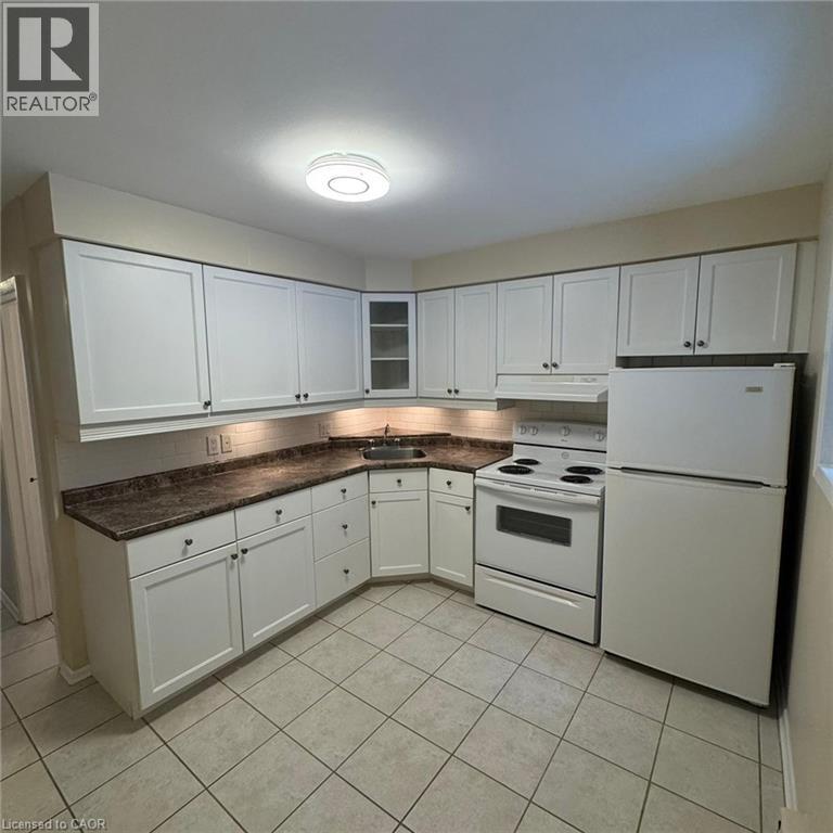 A kitchen with white cabinets and appliances.