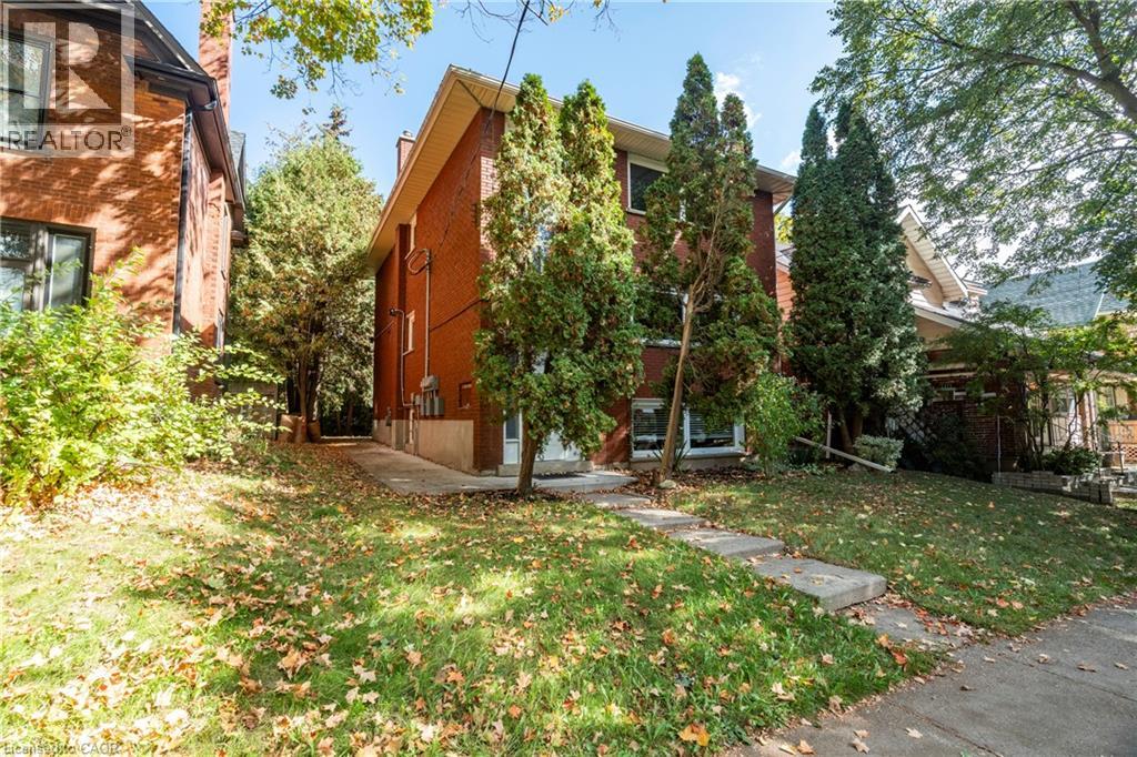 A tree in front of a brick building.