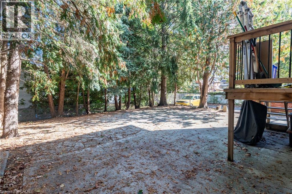 A backyard with a wooden deck and trees.
