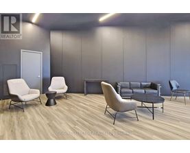 A modern living room with a grey couch, white chairs, and a black coffee table.