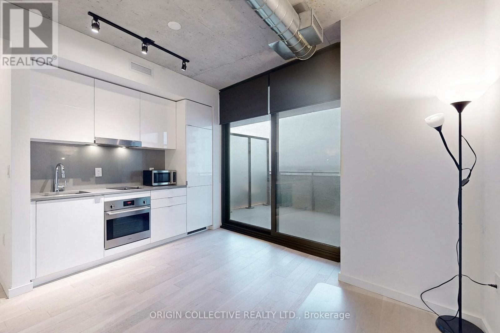 A modern kitchen with white cabinets and stainless steel appliances.
