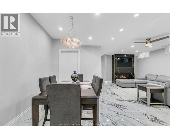 A modern dining room with a wooden table and grey chairs.