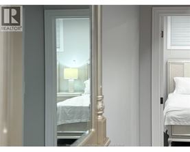 A bedroom with a bed and a lamp.