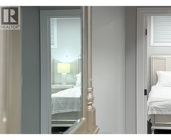 A bedroom with a bed and a lamp.