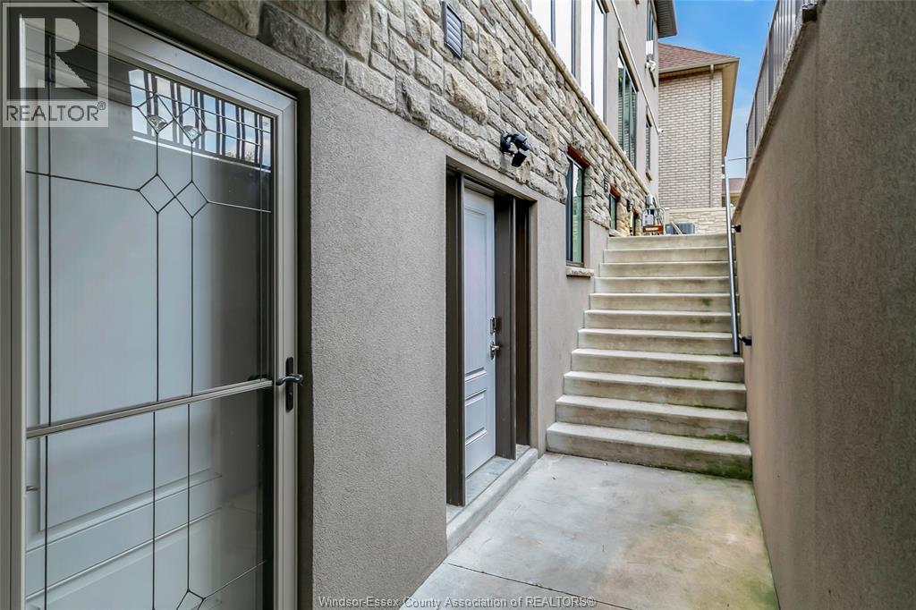 A stone building with a glass door and a set of stairs leading up to it.