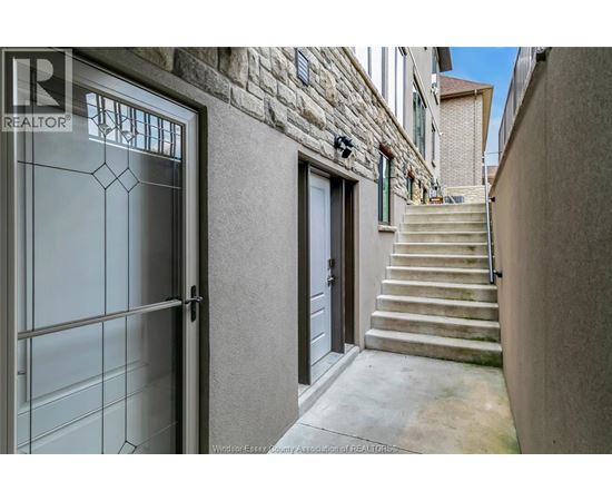 A stone building with a glass door and a set of stairs leading up to it.