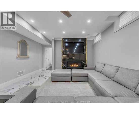 A modern living room with a grey sofa and a fireplace.