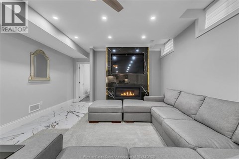 A modern living room with a grey sofa and a fireplace.