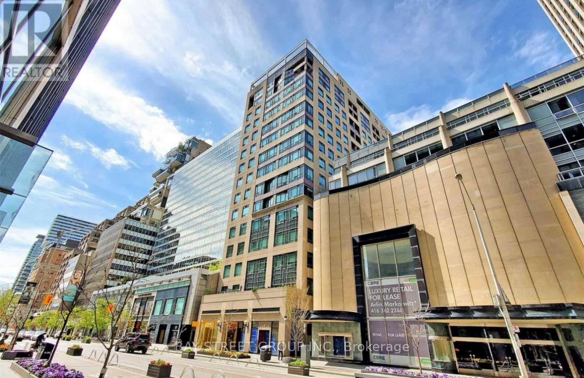 A modern building with a glass facade stands tall in a cityscape.