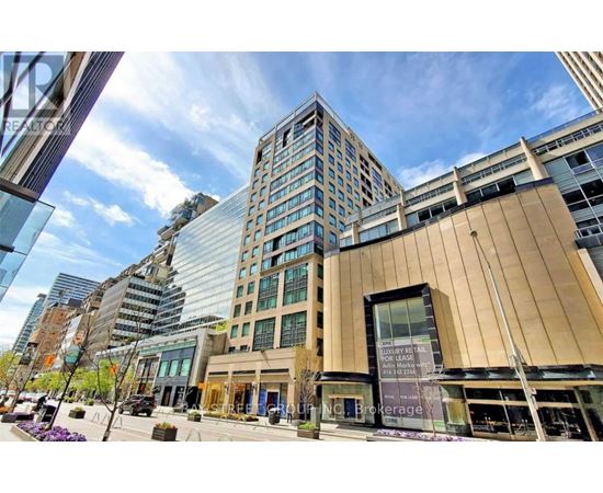 A modern building with a glass facade stands tall in a cityscape.