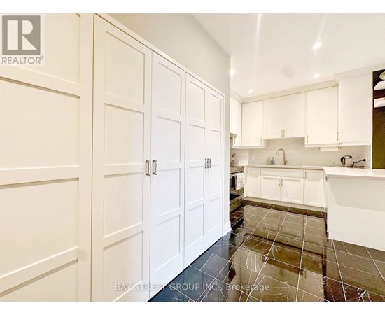 A kitchen with white cabinets and a tile floor.