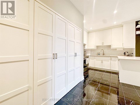 A kitchen with white cabinets and a tile floor.