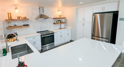 A modern kitchen with white cabinets and stainless steel appliances.